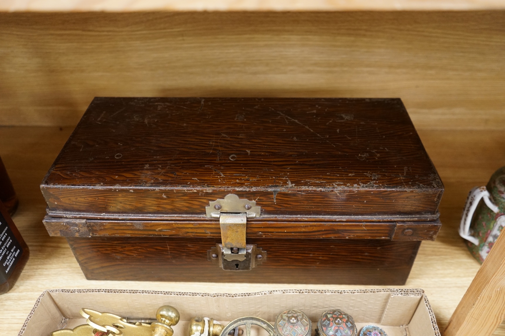 A brush grained tin trunk containing brass furniture mounts and fittings and a micromosaic miniature photo frame and hand mirror, trunk 47cm wide (a.f.)
